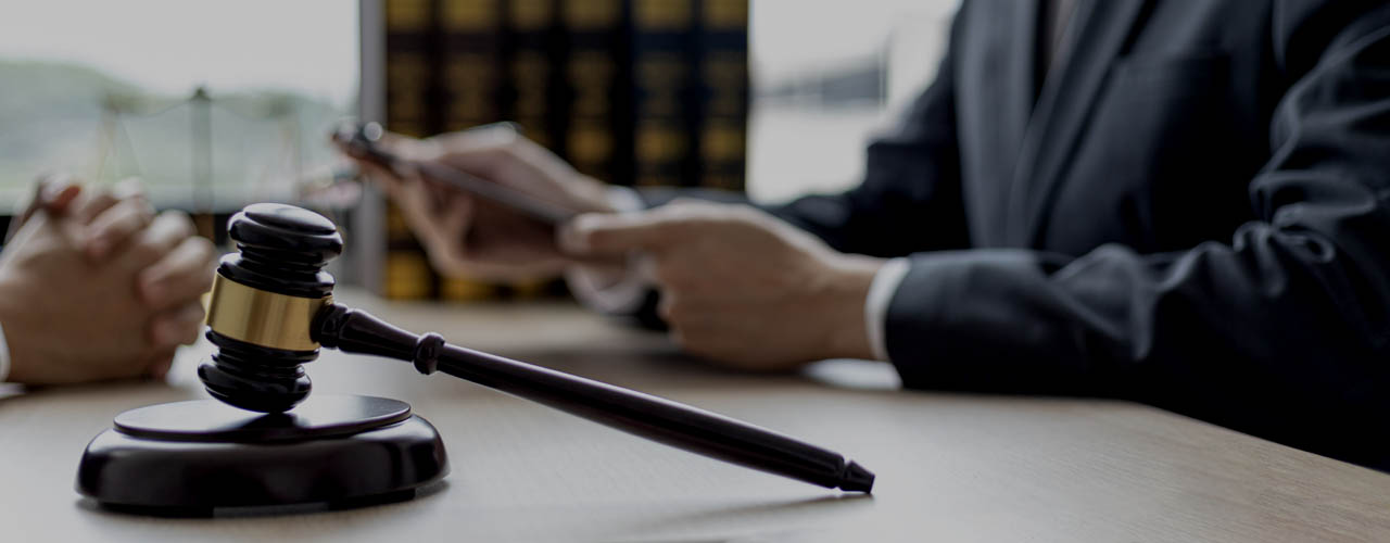 A small court judge’s hammer is placed on the lawyer’s table, th