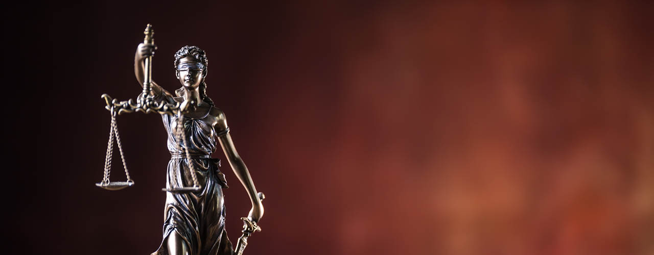 Lady Justicia holding sword and scale bronze figurine on wooden table