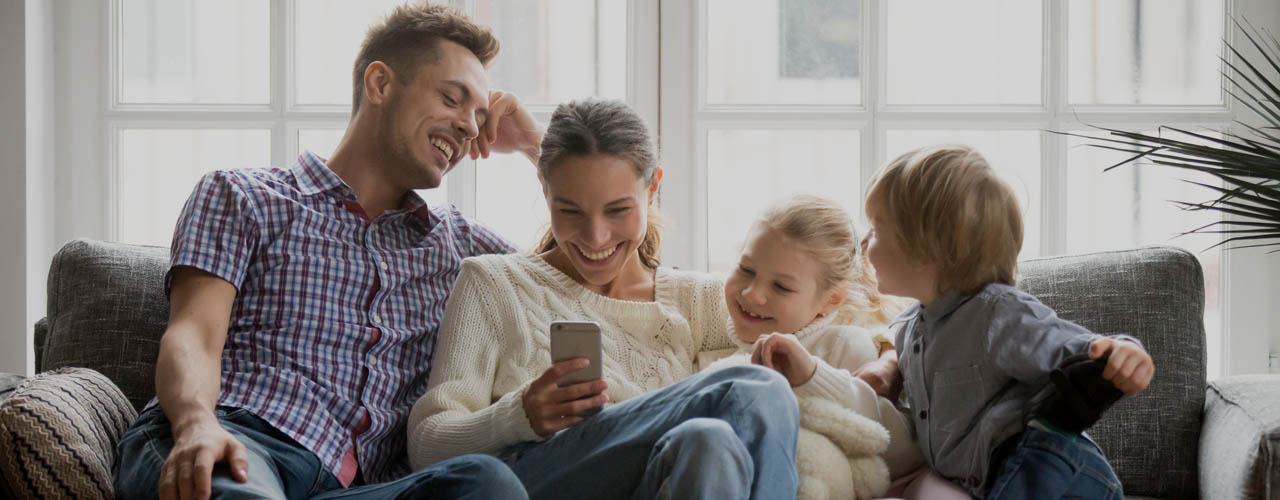 Cheerful Young Family With Kids Laughing Watching Funny Video On